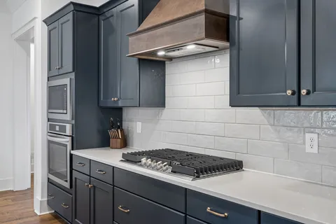 a stove top oven sitting inside of a kitchen
