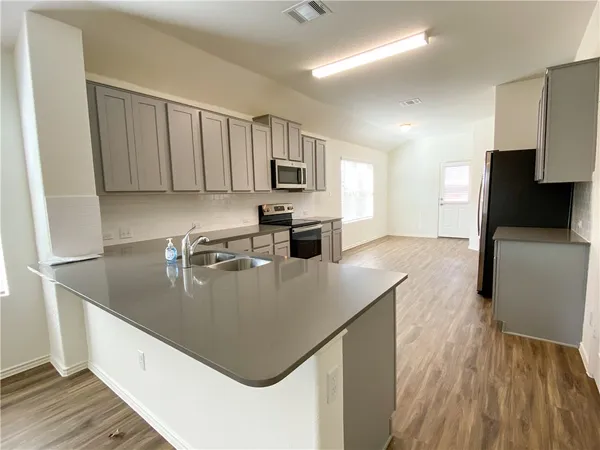 a kitchen with stainless steel appliances granite countertop a sink refrigerator and microwave