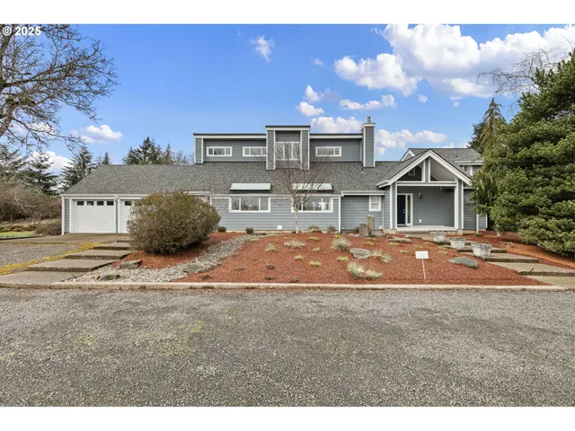 a very nice looking house with a big yard and large trees