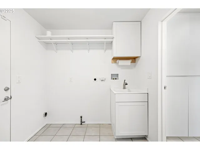 a view of an empty room with wooden floor and windows