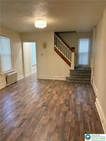 a kitchen with stainless steel appliances granite countertop a refrigerator a stove and a sink with wooden floor