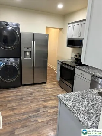 a kitchen with granite countertop cabinets stainless steel appliances and sink