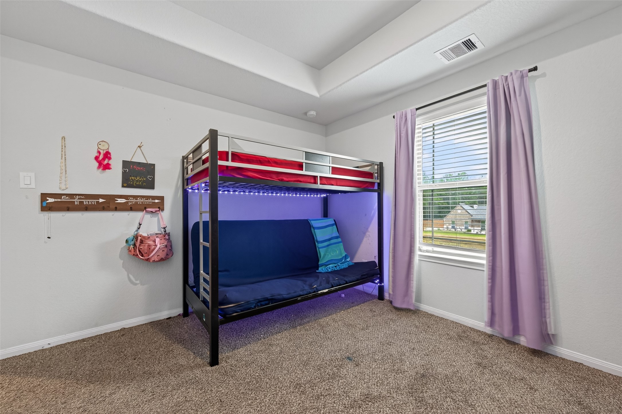 16601 Crosby Street Conroe, TX 77303 - Photo 35 of 50 Cozy secondary bedroom with tray ceiling, soft carpeting, and a bright window offering plenty of natural light.