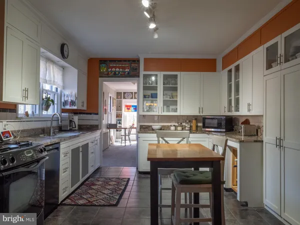 a kitchen with a table chairs sink and cabinets