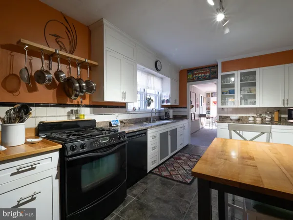 a kitchen with a table chairs sink and cabinets