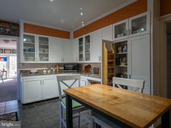 a kitchen with stainless steel appliances granite countertop table chairs sink and cabinets