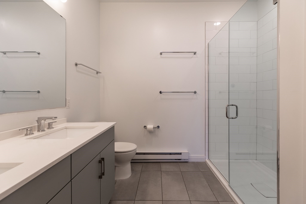 3531 Washington Street, Unit 322D Boston, MA 02130 - Photo 14 of 24 a bathroom with a sink a toilet and shower
