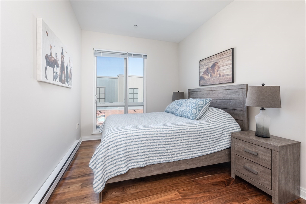 3531 Washington Street, Unit 322D Boston, MA 02130 - Photo 16 of 24 a bedroom with a bed and wooden floor