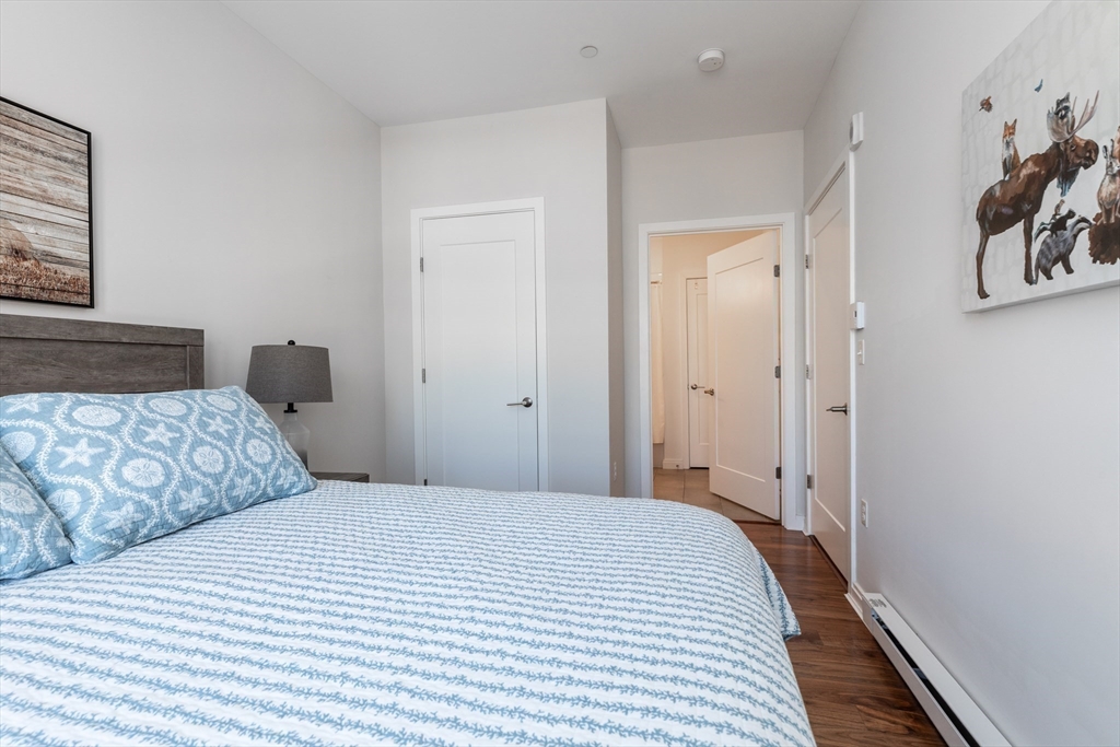 3531 Washington Street, Unit 322D Boston, MA 02130 - Photo 17 of 24 a bedroom with a large bed and wooden floor