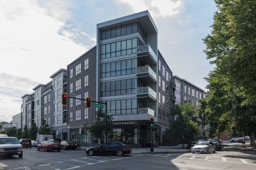 3531 Washington Street, Unit 322D Boston, MA 02130 - Photo 20 of 24 a front view of a building with lot of cars and trees