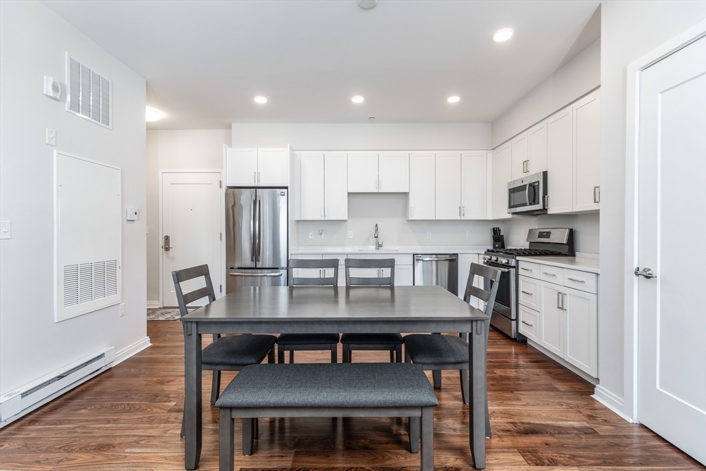 3531 Washington Street, Unit 322D Boston, MA 02130 - Photo 4 of 24 a kitchen with granite countertop a refrigerator stove microwave and cabinets