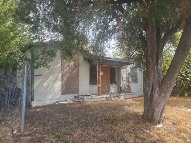 a view of house with backyard and a tree