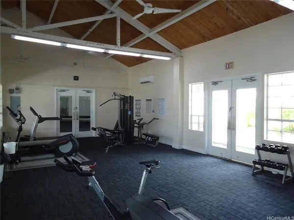 a room with gym equipment and a wooden floor
