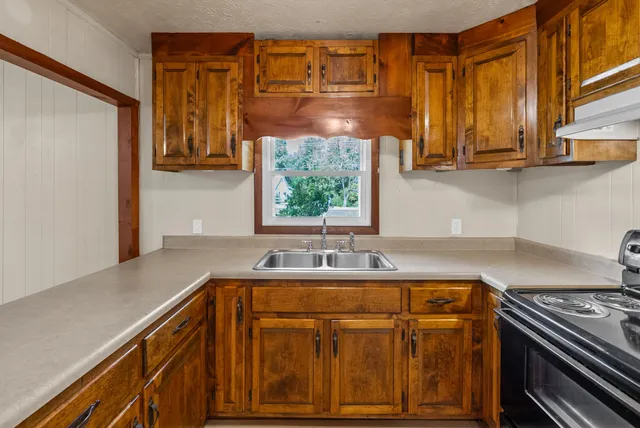 a kitchen with stainless steel appliances granite countertop a sink and a stove