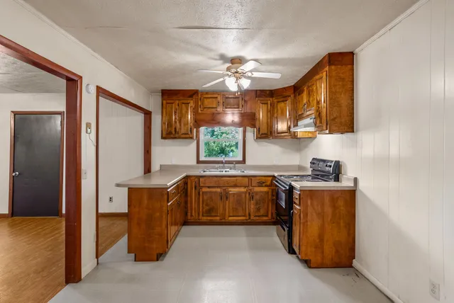 a kitchen that has a lot of cabinets in it and stainless steel appliances