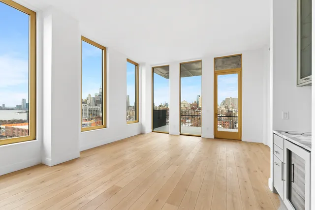 a kitchen with a sink dishwasher and white cabinets with wooden floor