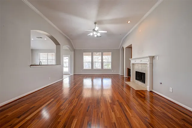 wooden floor fireplace and windows in an empty room