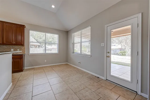 a view of an empty room with a kitchen and a window