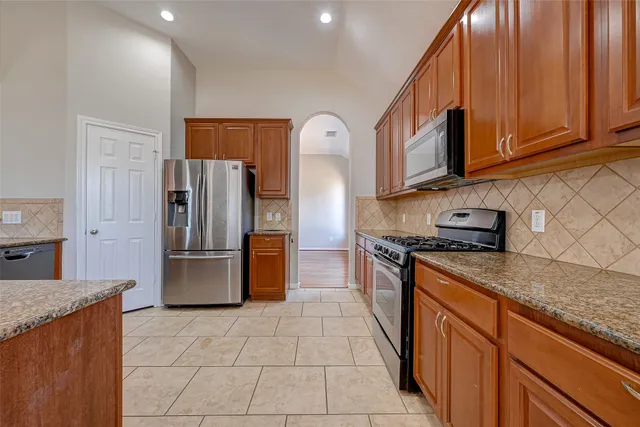 a kitchen with stainless steel appliances granite countertop a refrigerator stove and sink
