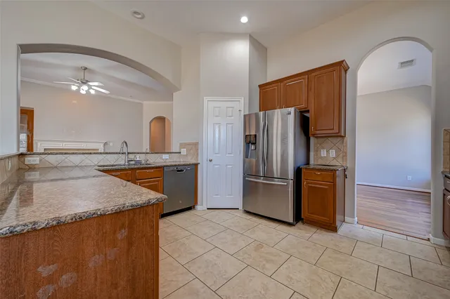 a large kitchen with a stainless steel appliances granite countertop a refrigerator and a sink