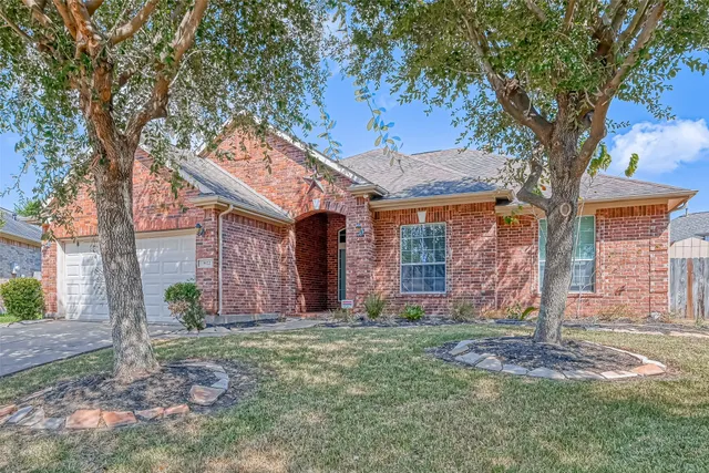 a view of a brick house with a tree in front of it