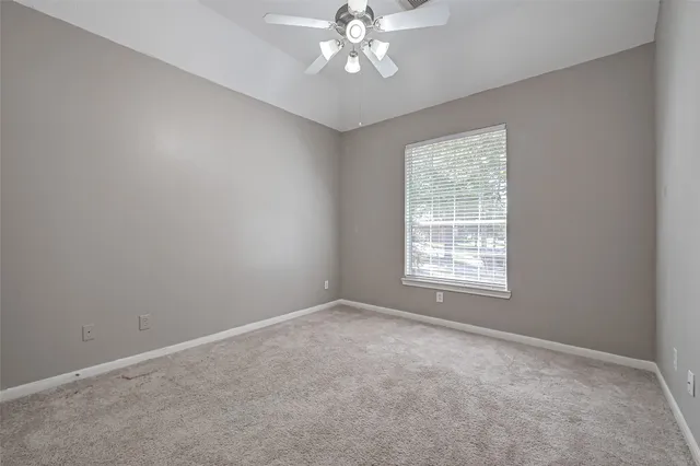 a view of an empty room with a chandelier fan