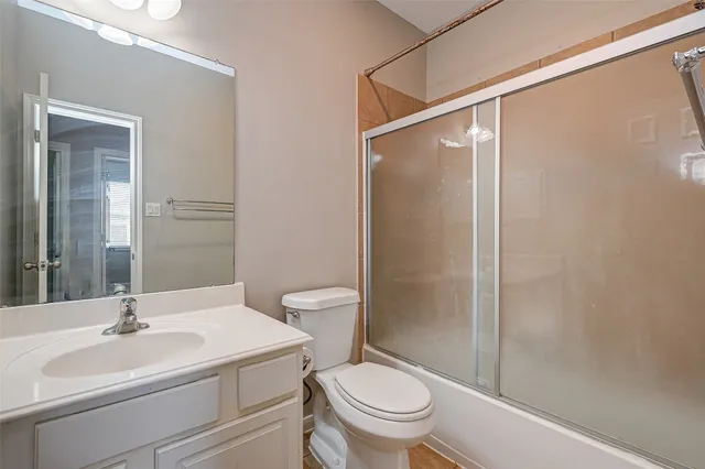 an empty room with windows and chandelier fan