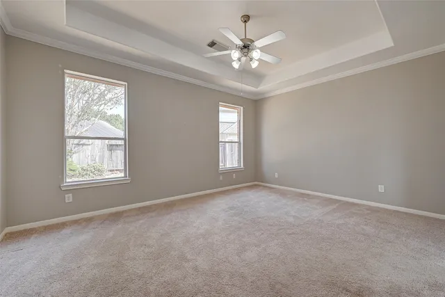 a view of an empty room with a chandelier fan