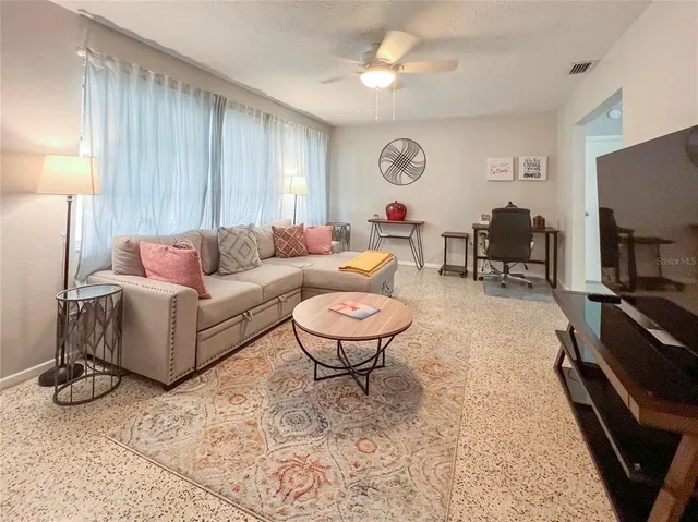 a living room with furniture a window and a flat screen tv