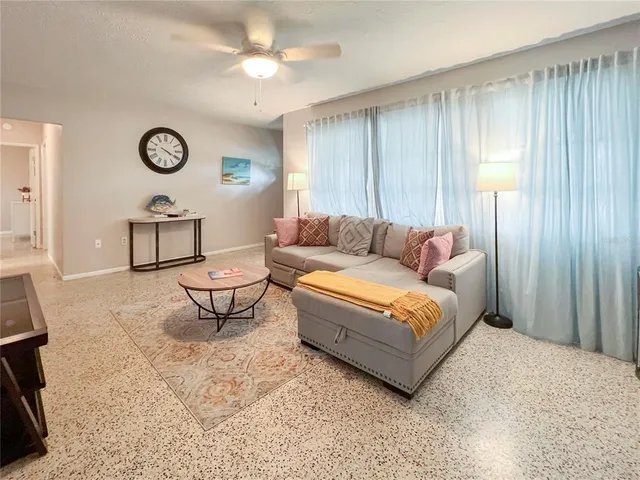 a living room with furniture a clock and a window