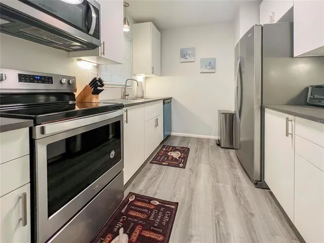 a kitchen with granite countertop a stove and a refrigerator