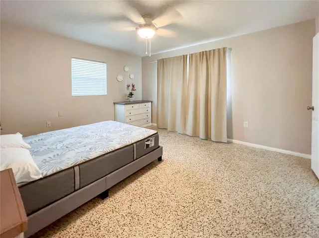 a spacious bedroom with a bed and a window