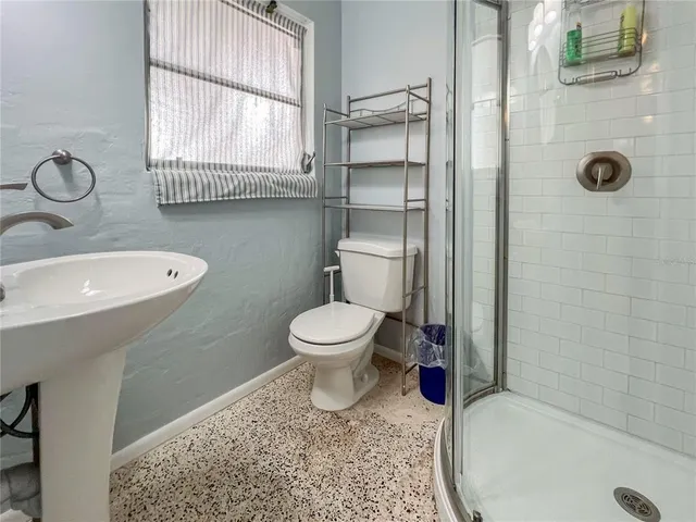 a bathroom with a toilet sink a window and shower