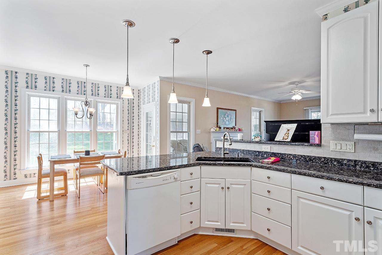 214 Silver Lining Lane Cary, NC 27513 - Photo 2 of 3 a kitchen with kitchen island granite countertop a sink a stove and cabinets