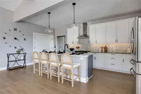 a kitchen with white cabinets and stainless steel appliances
