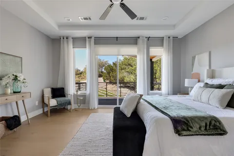 a bedroom with a bed and large windows