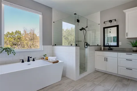 a bathroom with a tub sink and mirror