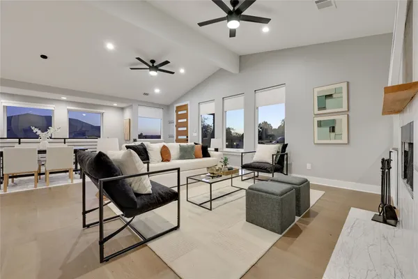 a kitchen with stainless steel appliances granite countertop a refrigerator a sink dishwasher a stove a dining table and chairs with wooden floor