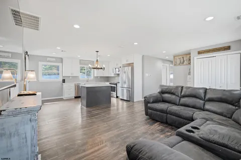 a living room with furniture and kitchen view