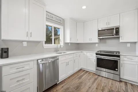 a kitchen with granite countertop cabinets stainless steel appliances and a sink