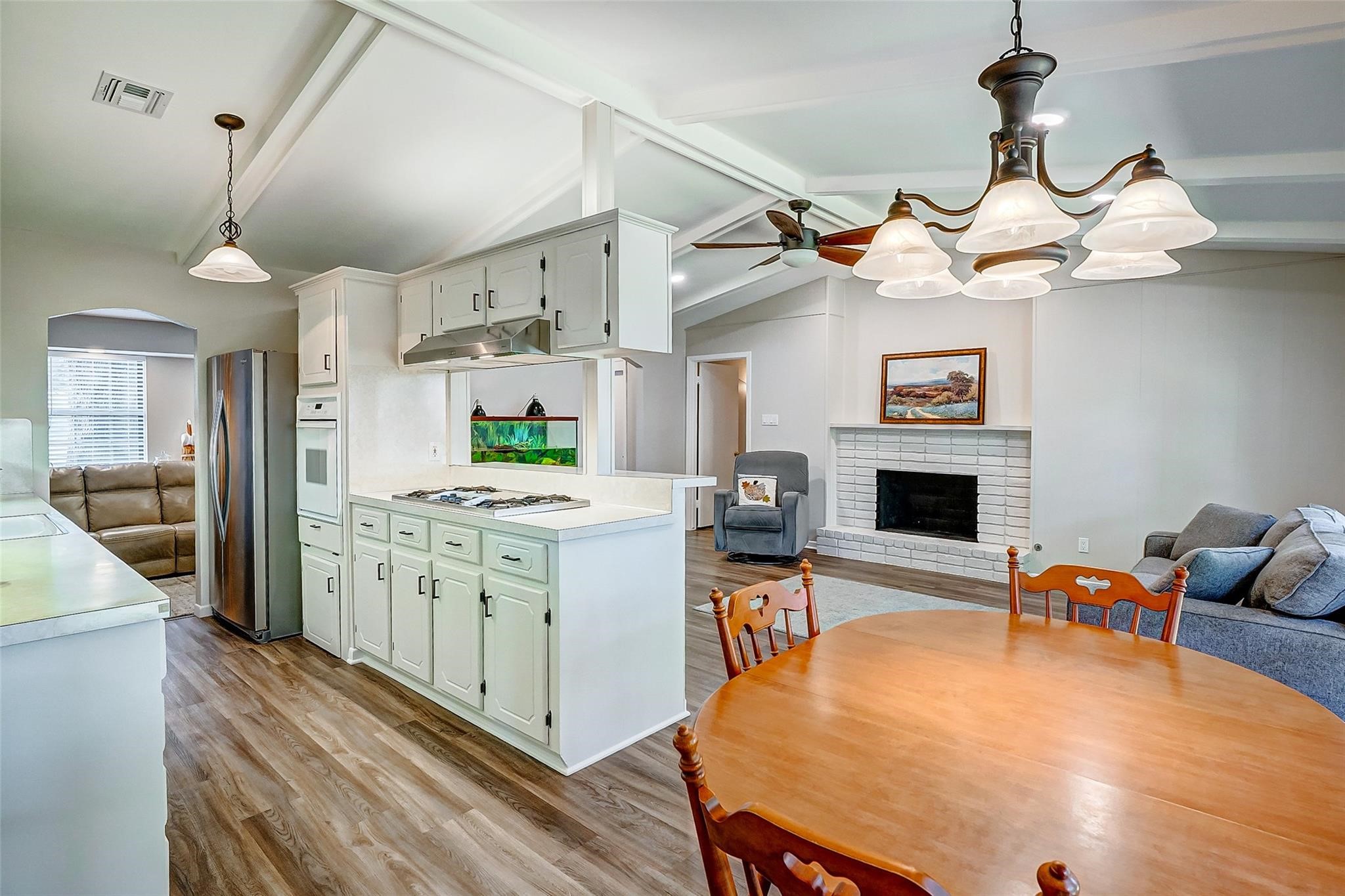 9218 Hammerly Boulevard Houston, TX 77080 - Photo 14 of 40 a kitchen with stainless steel appliances kitchen island granite countertop a table chairs in it and wooden floors