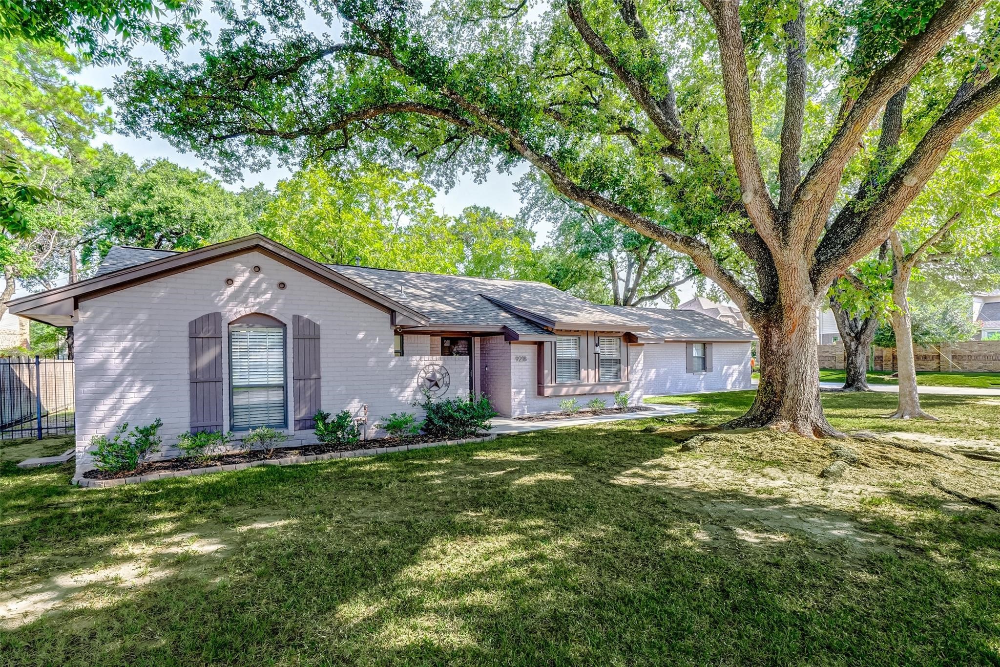 9218 Hammerly Boulevard Houston, TX 77080 - Photo 2 of 40 a view of a yard in front of a house with large trees