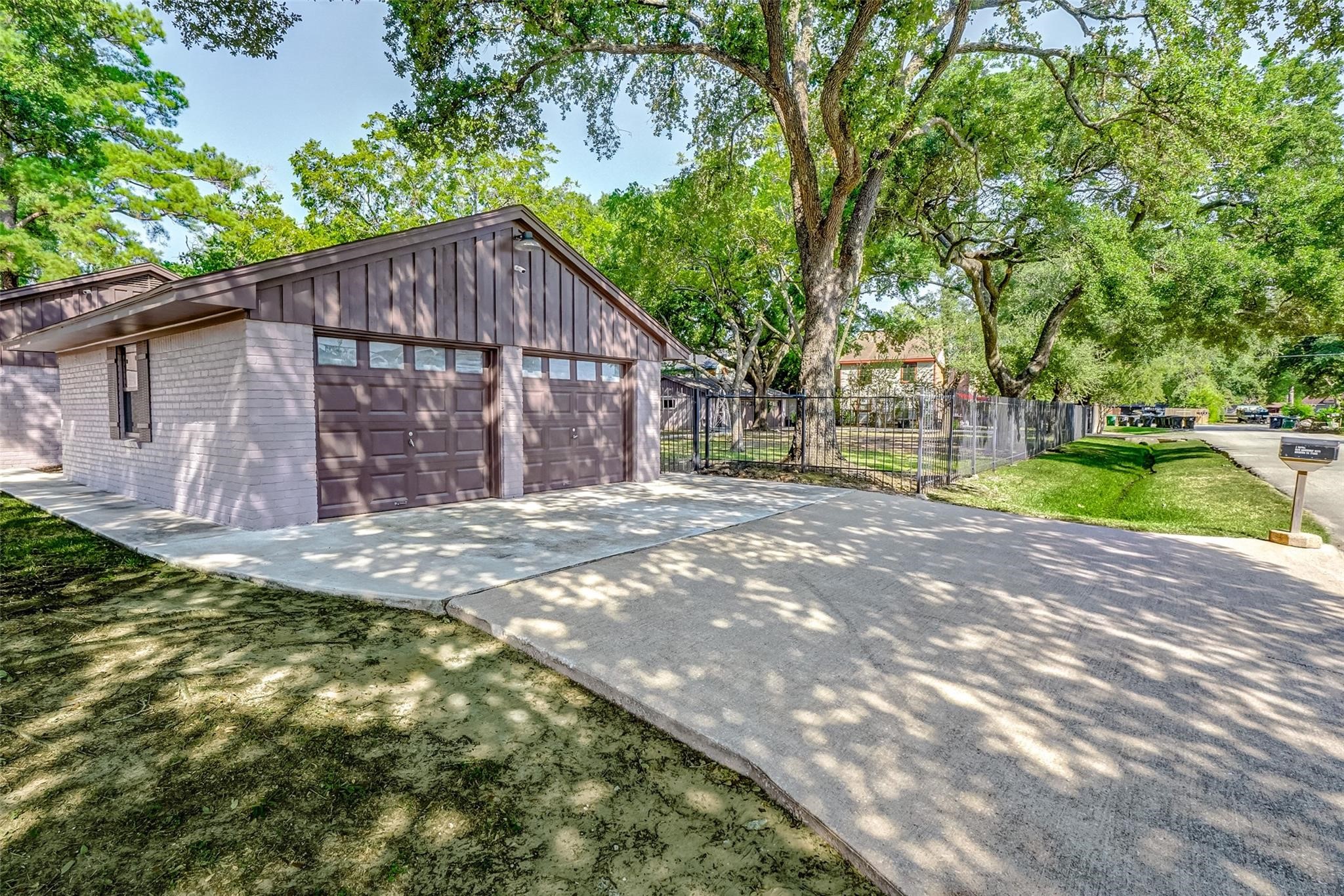 9218 Hammerly Boulevard Houston, TX 77080 - Photo 6 of 40 a backyard of a house with large trees and a wooden fence