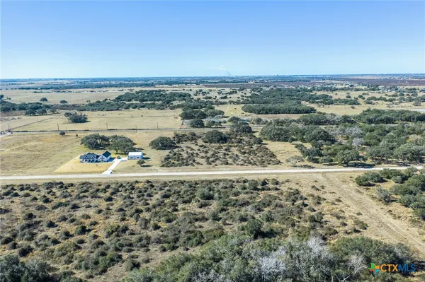 a view of a field with trees in background