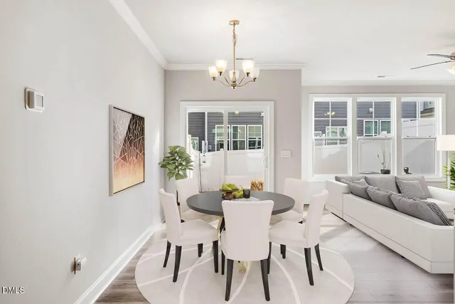 a dining room with furniture a chandelier and wooden floor