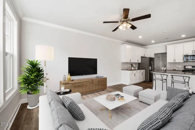 a living room with furniture kitchen view and a potted plant