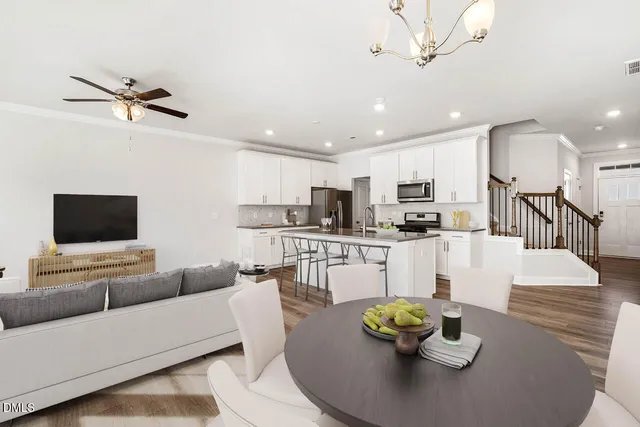 a living room with stainless steel appliances furniture and a view of kitchen