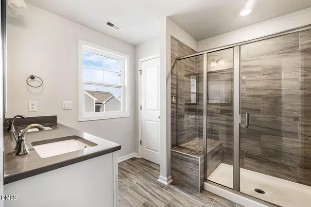 a bathroom with a shower sink and mirror