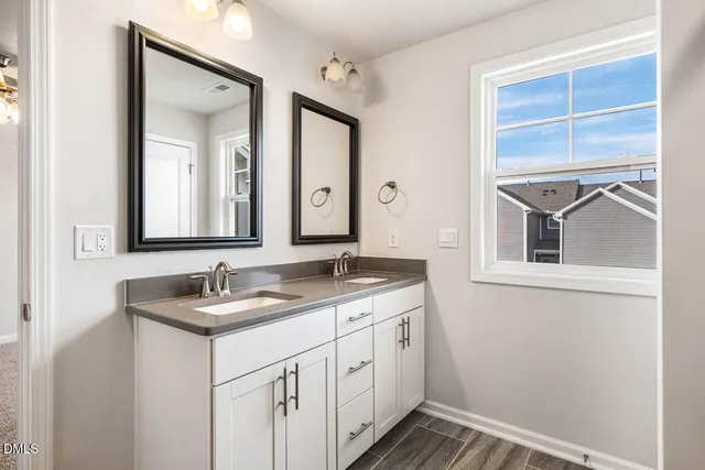 a bathroom with a double vanity sink and a mirror