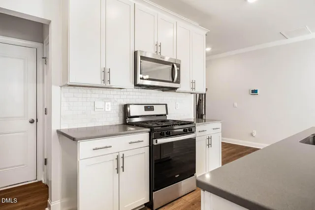 a kitchen with stainless steel appliances granite countertop a stove a microwave and a refrigerator